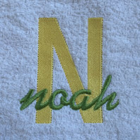 embroidered name in cursive on baby blanket with blue trim