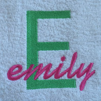 embroidered name in cursive on baby blanket with pink trim
